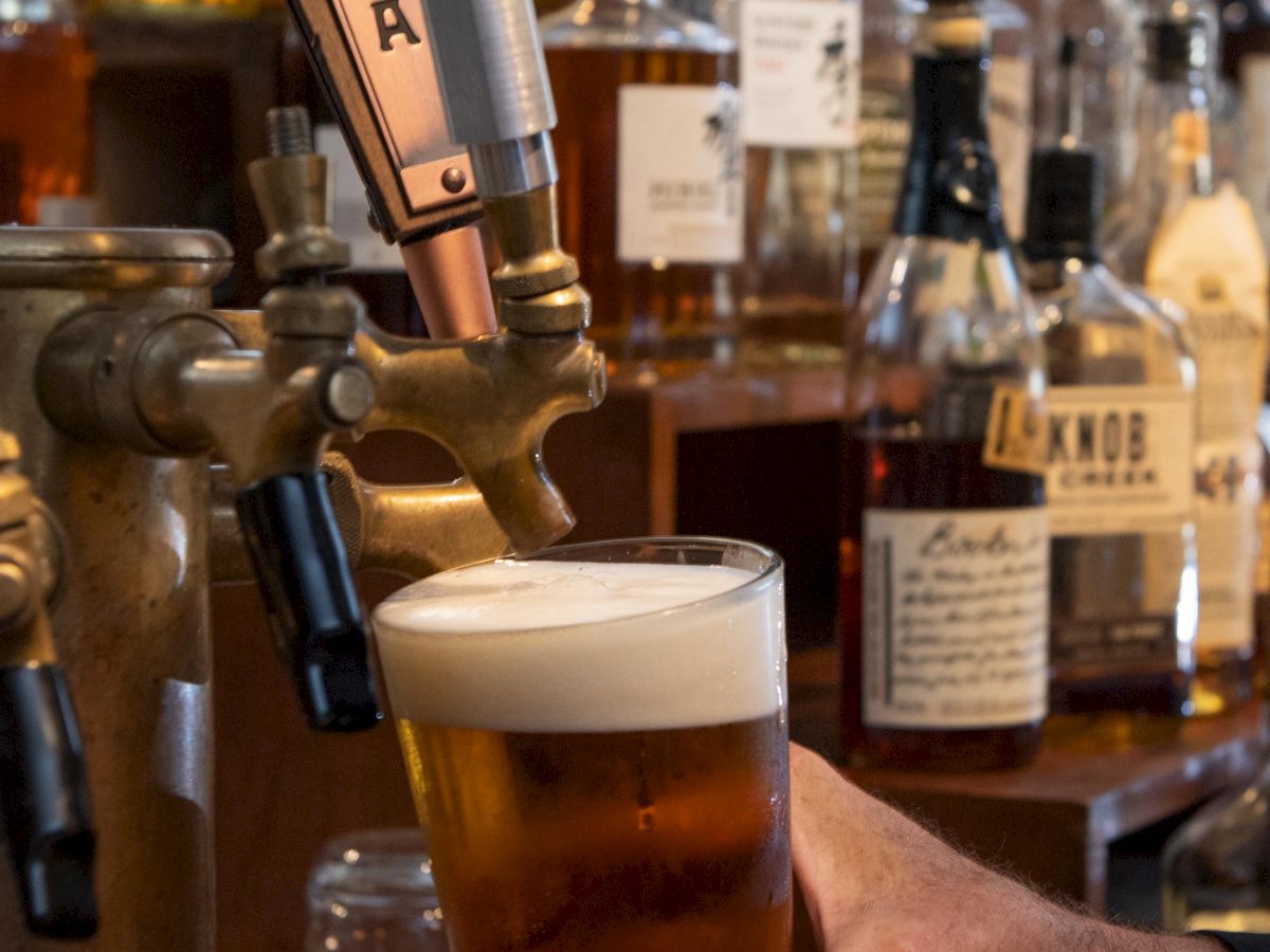 A person is pouring beer from a tap labeled 