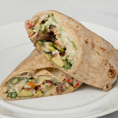 A stuffed wrap/burrito with vegetables and melted cheese on a white plate.